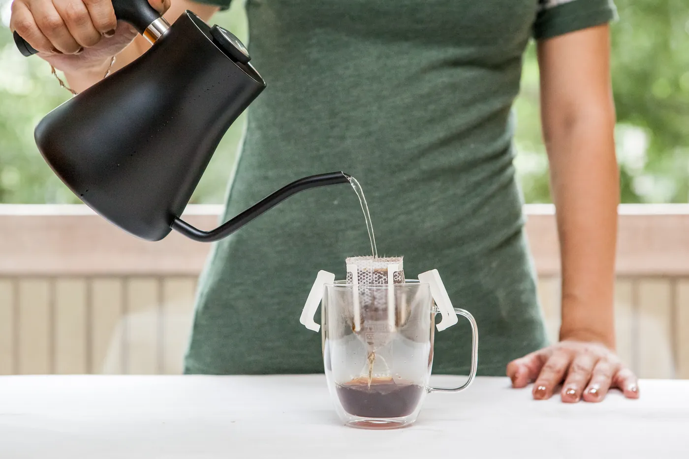 Single-serving pour-over coffee brewing over a cup with hot water
