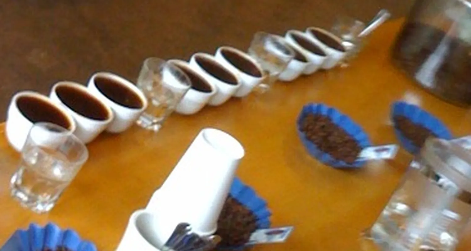 Cupping bowls, spoons, and roasted bean samples on a wooden tasting table