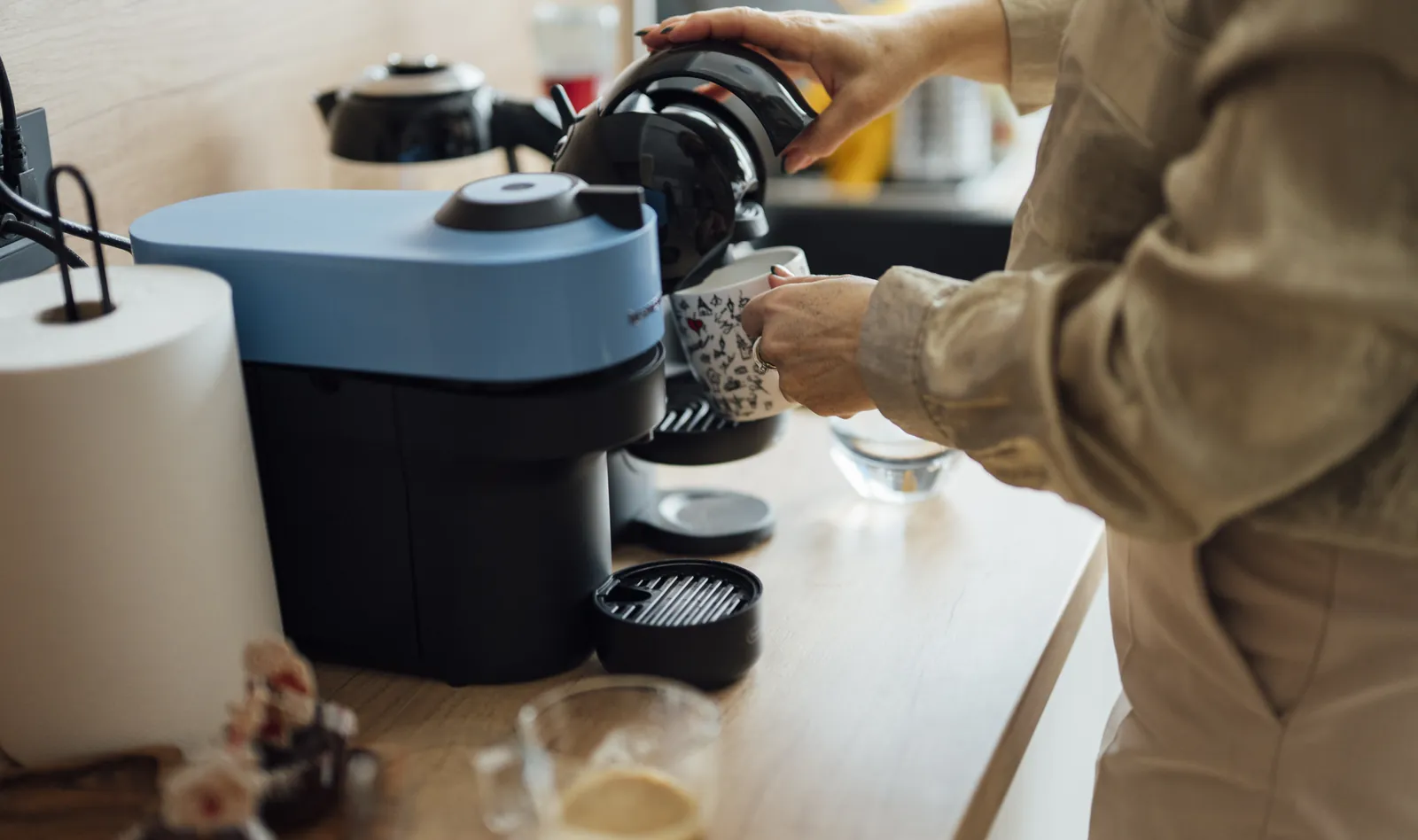 Bright home kitchen counter with a coffee machine, cup, and morning brewing setup
